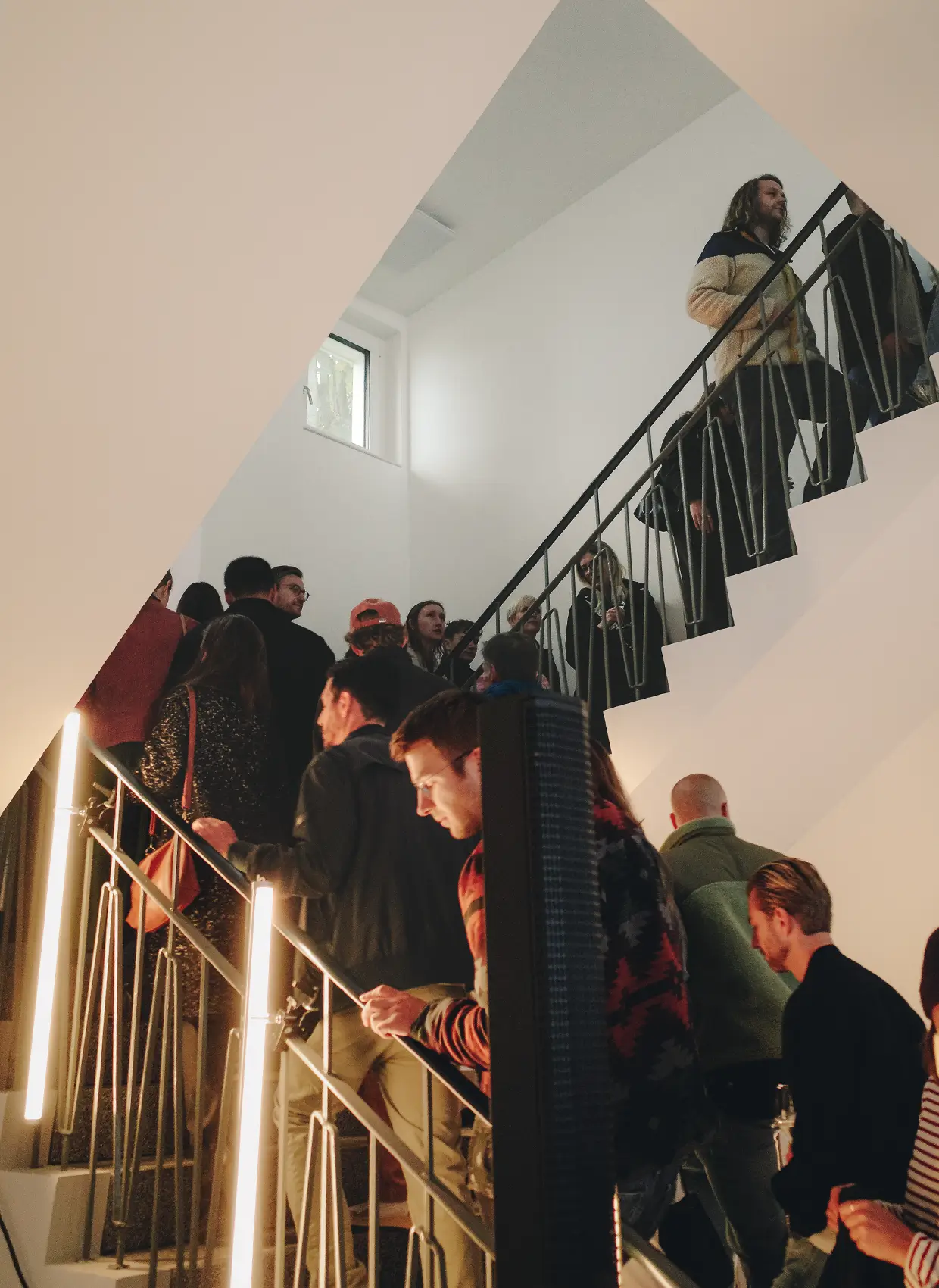 Eine Schlange aus Menschen geht den beleuchteten Treppenaufgang im Neuen Areal für eine Führung nach oben.